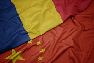 waving colorful flag of china and national flag of romania.
