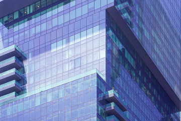 Fototapeta na wymiar Glass blue square Windows of facade modern city business building skyscraper. Modern apartment buildings in new neighborhood. Windows of a building, texture.