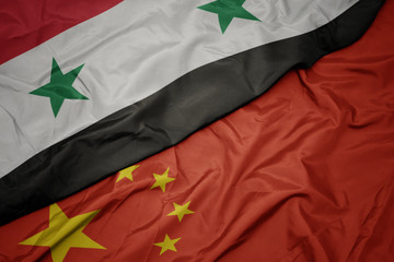waving colorful flag of china and national flag of syria.