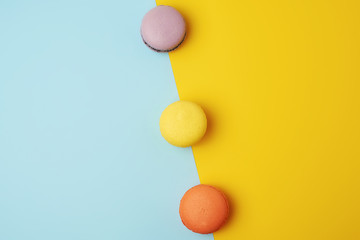 multi-colored baked round macarons on a colored background
