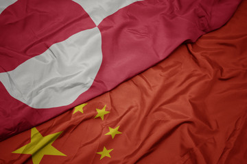 waving colorful flag of china and national flag of greenland.