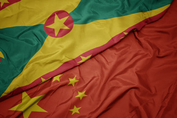 waving colorful flag of china and national flag of grenada.