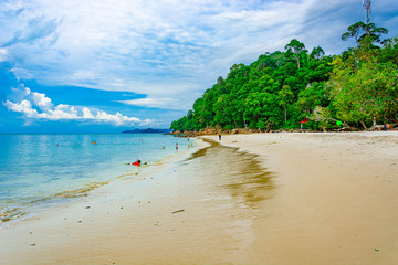 Beautiful beach with clear blue water and green forest mountains at Langkawi island