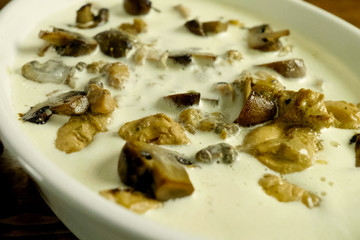Fried pieces of chicken with mushrooms, in milk in a cup