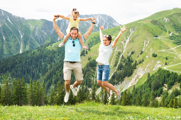 Happy Family Jumping In Mountains