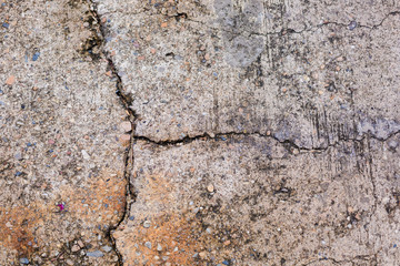 Worn and cracked asphalt with big cracks. Old road concrete texture with cracks. Cement cracked background. Cracks on concrete.