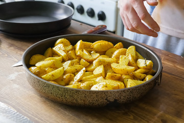 Fried potatoes with spices in pan. Spices on the potato.