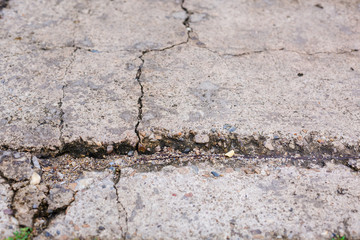 Worn and cracked asphalt with big cracks. Old road concrete texture with cracks. Cement cracked background. Cracks on concrete.