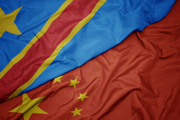 waving colorful flag of china and national flag of democratic republic of the congo.
