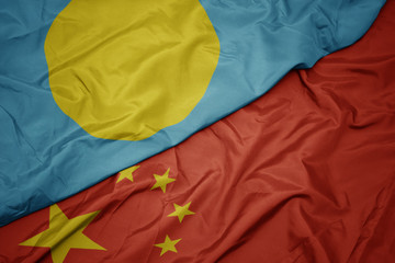 waving colorful flag of china and national flag of Palau.