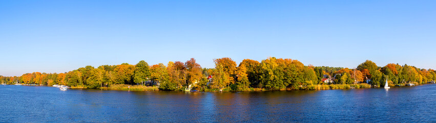 Obraz premium Panorama von einem See mit Laubbäumen im Herbst