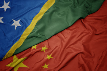 waving colorful flag of china and national flag of Solomon Islands.