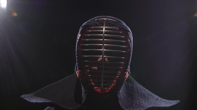 Kendo guru sitting on the floor in an traditional helmet. Close-up
