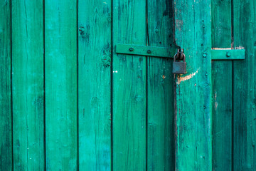 Green wooden background texture with padlock. Vertical planks, bars