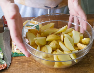 Raw potatoes cutting and peeling on table in a plate