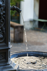 Fresh drinking water sprinkling out of a beautiful old fountain in Zurich - closeup