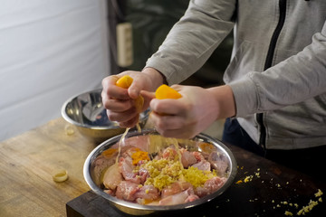 Squeezing lemons in a plate with chicken meat. lemon
