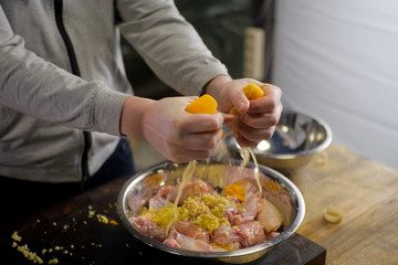 Squeezing lemons in a plate with chicken meat. lemon