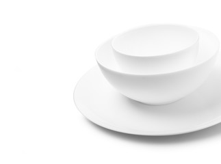 Set of white dishes on table on light background.