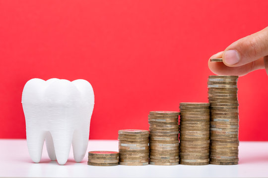 Stack Of Coins In Front Of Healthy Tooth