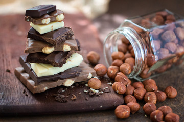 The different grades of chocolate put by the hill on a wooden board, with a filbert can on a rusty metal surface. 