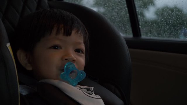 happy baby sitting on car seat with safety driving road trips travel