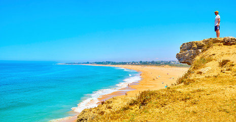 A tourist watching to The Faro de Trafalgar Beach, a broad beach of The Cabo de Trafalgar Cape...