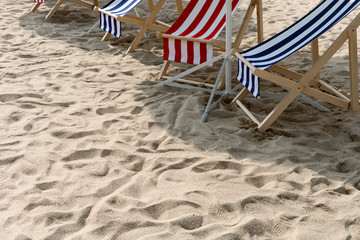 sun loungers in the shade on sand with copy space