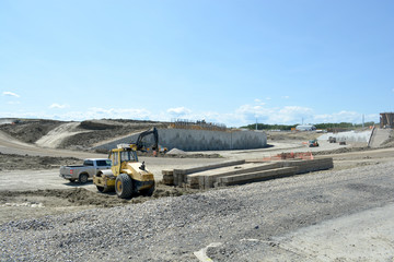 Highway construction site with concrete and steel reinforcement and equipment.
