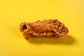 side view fresh deep fried chicken wing on yellow background