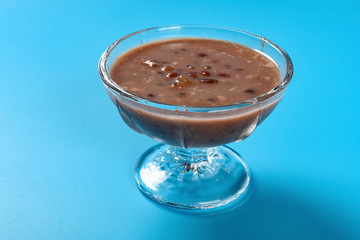 side view Chinese syrup of red bean and sago with shredded coconut in a glass bowl