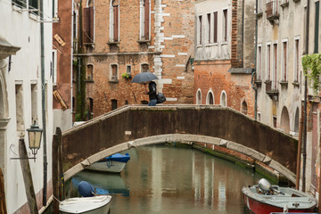 Fototapeta premium Wąski kanał z łodziami w Wenecji