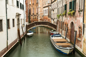 Fototapeta na wymiar Narrow canal with boats in Venice