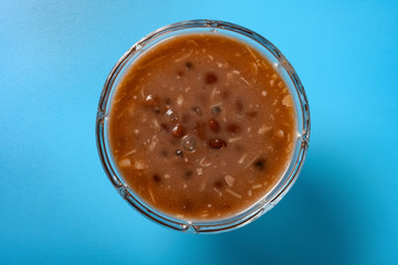top view Chinese syrup of red bean and sago with shredded coconut in a glass bowl