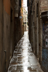 Fototapeta na wymiar Narrow street a rainy day in Venice