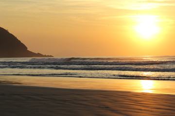 The sun rising at Sao Lourenco beach, Bertioga, Brazil on a summer day 
