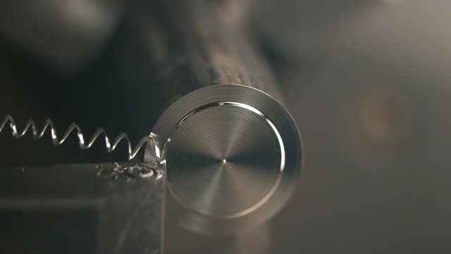 SLOW MOTION, MACRO, DOF: Lathe tool cutting a small groove into the middle of a shiny metal rod. CNC machine fine cutting a circle into the top of an aluminium workpiece. Micro machining a steel bar.