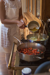 Pan with caramelised tomatoes cherry process of cooking and adding ingredients hands
