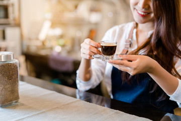 Professional Asian woman Barista preparing coffee at front counter serving coffee cup to customer occupation, part-time,job or owner business working woman happy selling and making drink beverage