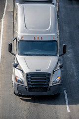 Long haul big rig semi truck tractor transporting semi truck driving on the road