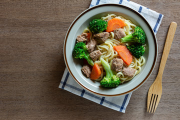 top view of stir fried japanese noodles with tuna and vegetables in a ceramic dish. homemade style food concept.