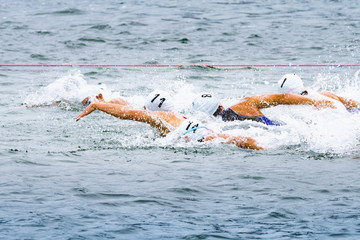 力泳するトライアスロン大会スイム競技者