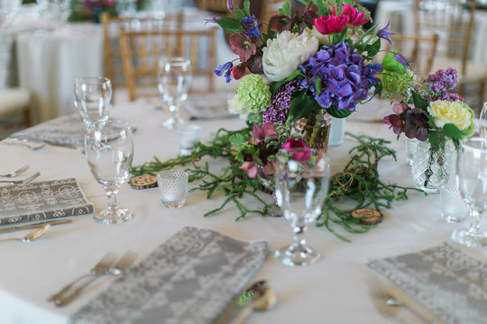 Colorful wedding arrangements on table, white peonies, blue and hot pink flowers, reception decor, bohemian table flowers