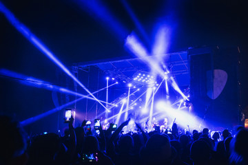 Crowd at concert - summer music festival. Fun concert party blue light background