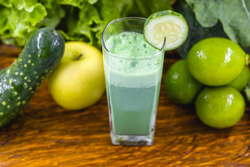 Green smoothie on dark wood background. Healthy smoothie herbal cocktail. Green fruits and vegetables. Healthy food and diet concept.