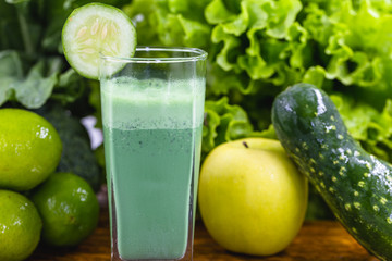 Green smoothie on dark wood background. Healthy smoothie herbal cocktail. Green fruits and vegetables. Healthy food and diet concept.