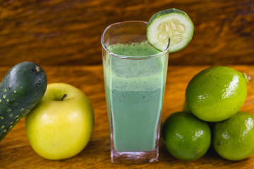 Green smoothie on dark wood background. Healthy smoothie herbal cocktail. Green fruits and vegetables. Healthy food and diet concept.