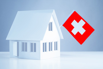 Immigration abroad. Miniature house with the flag of Switzerland. To leave for permanent residence...