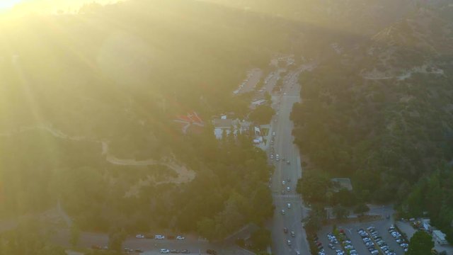 Aerial, tracking, drone shot, panning around the Vermont canyon road, buildings and the park, near the Griffith observatory and mount Hollywood, on a sunny, summer day, in Los Feliz, Los Angeles, USA