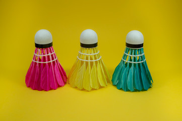 Colorful shuttlecocks on yellow background